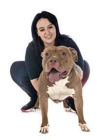 Portrait of young woman with dog against white background