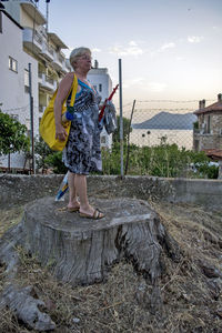 Full length of senior woman standing against sky