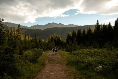 Father and son hike after day of fly fishing in rocky mountains