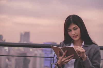 Businesswoman reading book at rooftop