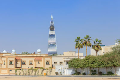 View of tower in city against blue sky