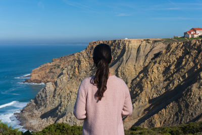 Rear view of woman looking at sea against sky