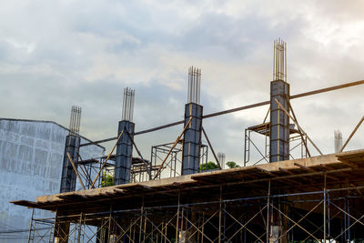 Low angle view of cranes against sky