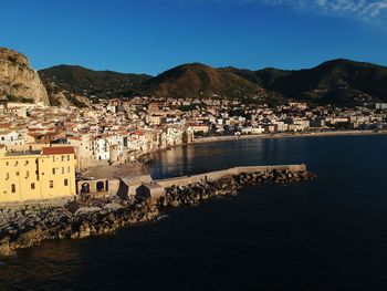 Scenic view of sea by town against sky