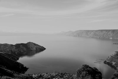 Scenic view of sea and mountains against sky