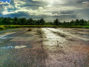 Empty road against cloudy sky