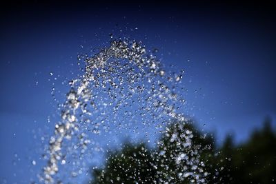 Close-up of water splashing against clear blue sky