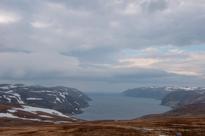 Scenic view of sea and mountains against sky