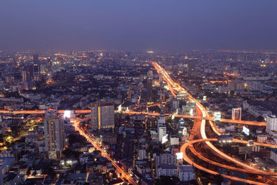 High angle view of illuminated city buildings against sky at night