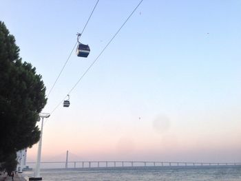 Overhead cable car over sea against clear sky