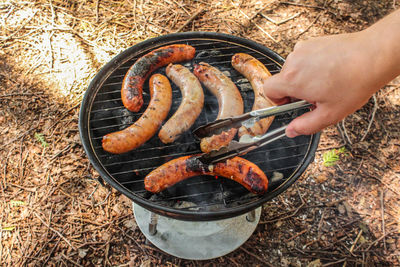 Close-up of person preparing food on barbecue grill