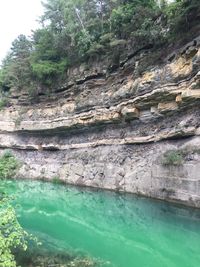 Scenic view of cliff by trees