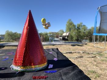 Close-up of hat against trees on field against sky
