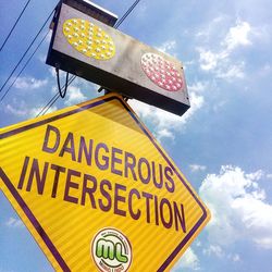 Low angle view of road sign against sky