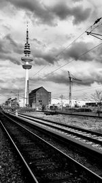 Railroad tracks against cloudy sky