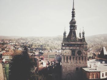 View of old tower in city against sky