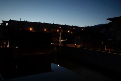 Illuminated street lights against clear sky at night