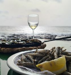 Fish and white wine in front of the sea