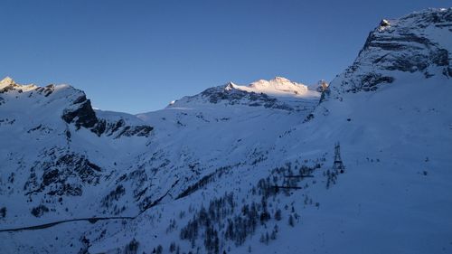 Scenic view of snowcapped mountains against clear sky