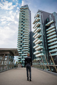 Rear view of man standing against modern building