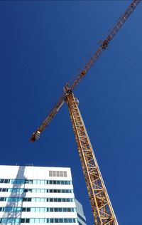 Low angle view of crane against sky