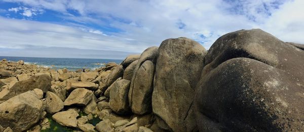 Panoramic view of rocks on beach against sky