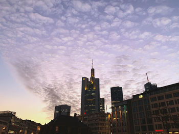 Buildings in city against cloudy sky