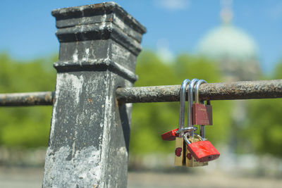 Close-up of padlocks on rusty metallic railing