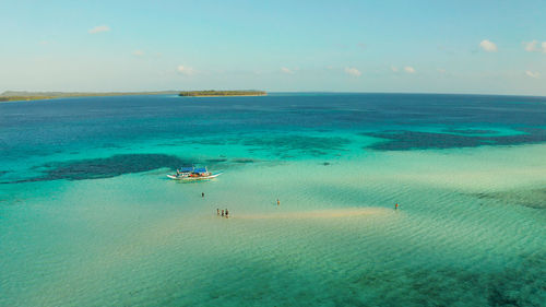 Sand bar among coral reefs in turquoise atoll water, top view. balabac, palawan, philippines.