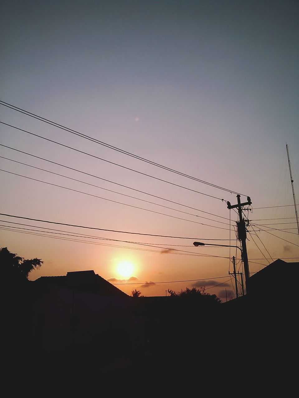 sunset, silhouette, sun, power line, electricity pylon, electricity, low angle view, power supply, connection, fuel and power generation, sky, built structure, cable, technology, clear sky, sunlight, building exterior, architecture, orange color, outdoors