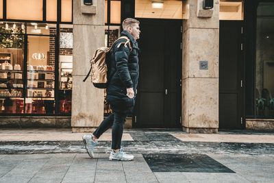 Full length of man standing on footpath in city