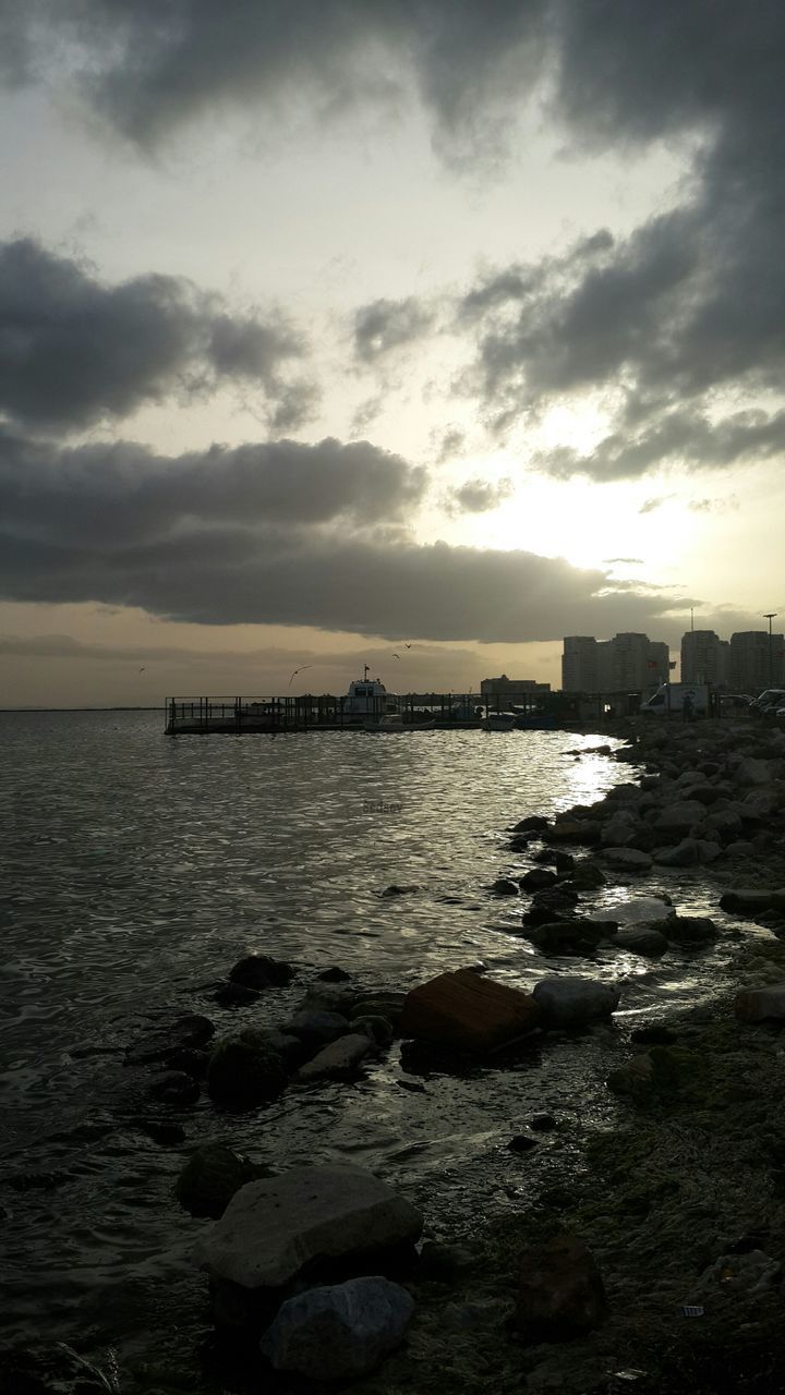 water, sea, sky, built structure, architecture, cloud - sky, sunset, horizon over water, building exterior, scenics, rock - object, beauty in nature, nature, cloudy, tranquil scene, tranquility, cloud, waterfront, rippled, outdoors