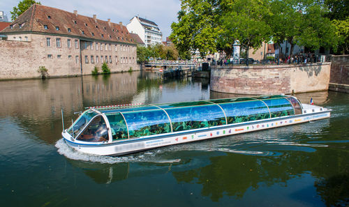 Boats in canal by buildings in city