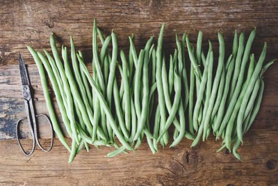 High angle view of green beans on wooden table