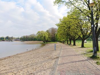 Footpath by river against sky