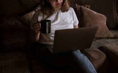 Young woman using laptop on the couch