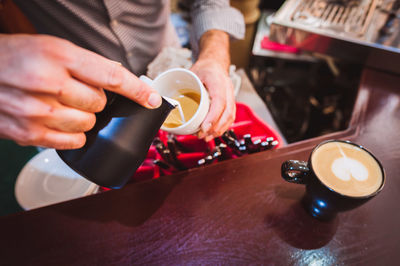 Close-up of cropped hand holding coffee cup