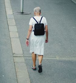 Rear view of woman walking on footpath