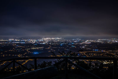 Illuminated cityscape against sky at night