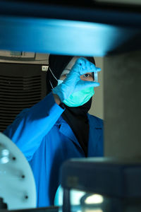 A pharmacist is carefully testing chemicals to make medicine in the laboratory