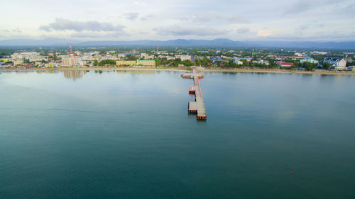 Scenic view of sea by buildings against sky