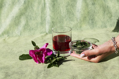 Midsection of woman holding glass of red wine