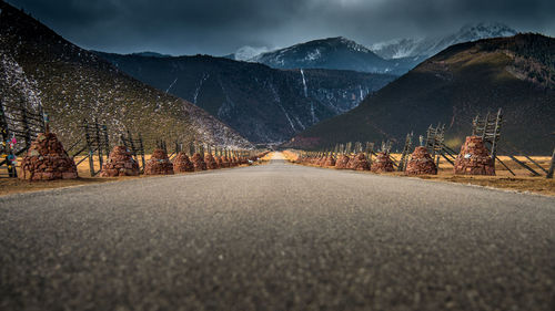 Road leading towards mountains against sky