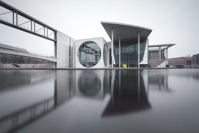 Bridge over river against buildings in city