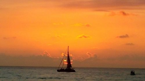 Sailboat in sea at sunset