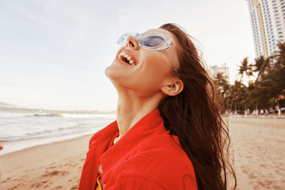 Portrait of young woman standing at beach