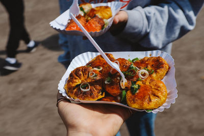 Cropped hand holding food in plate