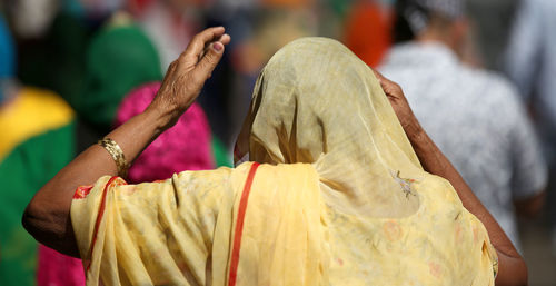 Rear view of people holding cross against blurred background