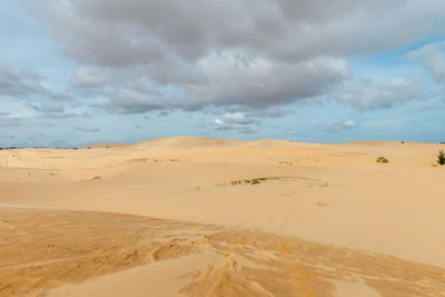 Scenic view of sand dunes against sky