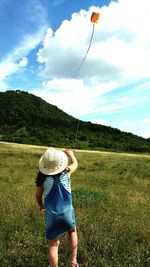 Boy holding rope on field against sky